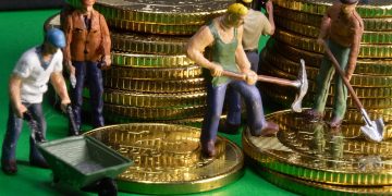 Wellbeing represented by piles of coins and men working