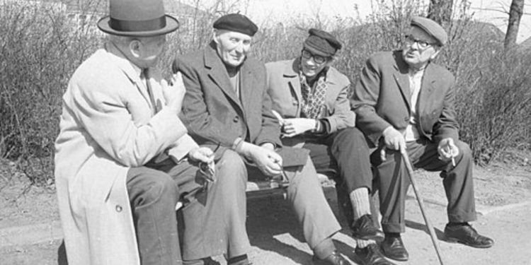 A black and white photo of pensioners on a bench