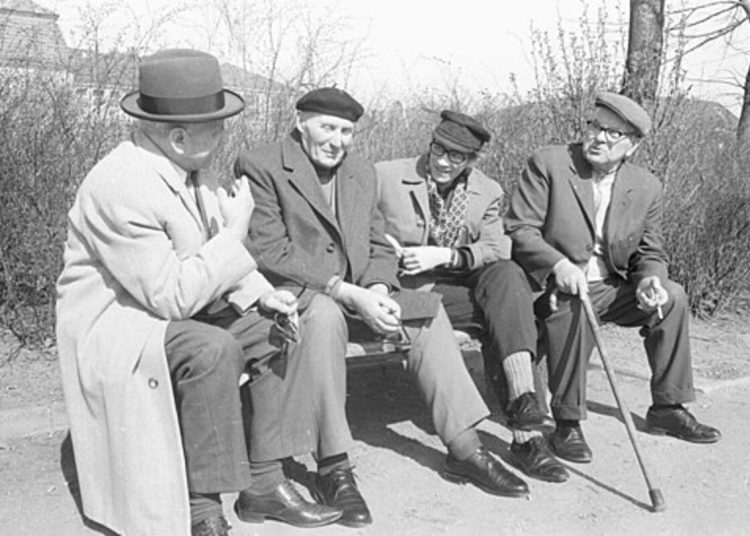 A black and white photo of pensioners on a bench