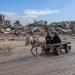 Gaza-Palestine Amid the massive destruction in Jabalia camp, a young man and his mother drive a cart through the camp's streets