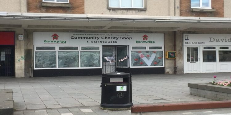 A photo of a derelict charity shop in a row of deserted looking shops in Bonnyrigg, Scotland.