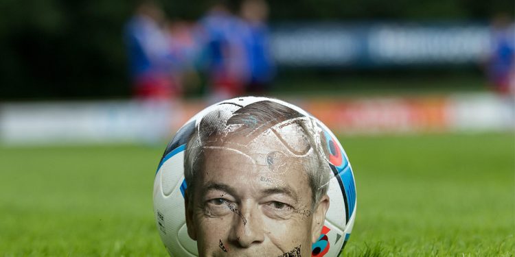 A football pitch with Farage and ball depicting Match of the Day political satire