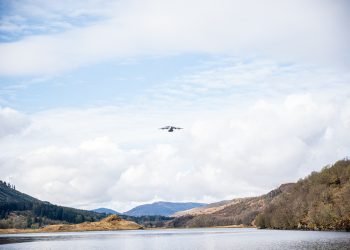 Military transport plane flying over Scottish loch