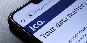 The Information Commissioner's Office ICO website seen on the smartphone corner. The United kingdom watchdog protects information rights, data privacy.